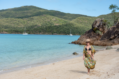 woman walking on white sand beach - Australian Stock Image