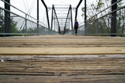 Woman walking over foot bridge - Australian Stock Image