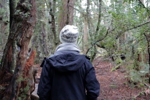 Woman walking through bush wearing beanie and jacket - Australian Stock Image