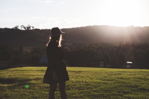 Woman watching the sunset over the hillside in the country - Australian Stock Image