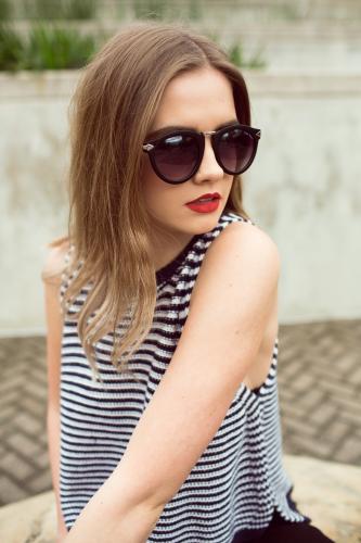 Woman wearing a striped top and sunglasses - Australian Stock Image