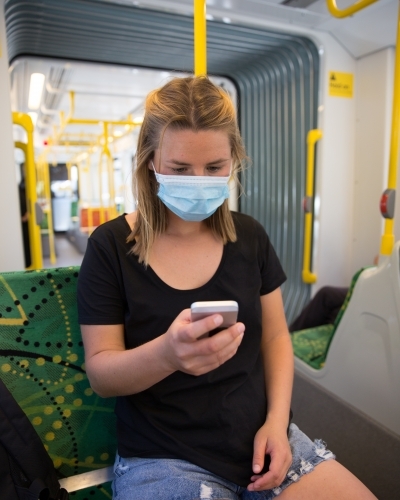 Woman Wearing Face Mask Travelling on Tram - Australian Stock Image