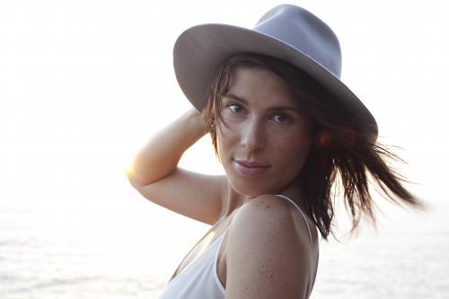Woman wearing hat near the ocean looking intently - Australian Stock Image