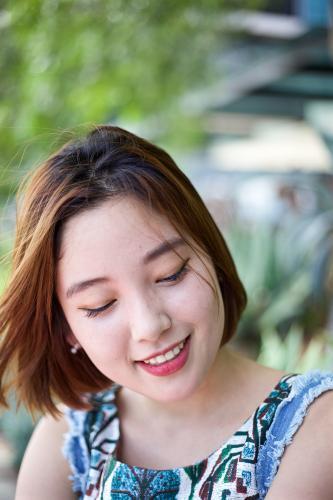 Woman with a smile, looking to the ground - Australian Stock Image