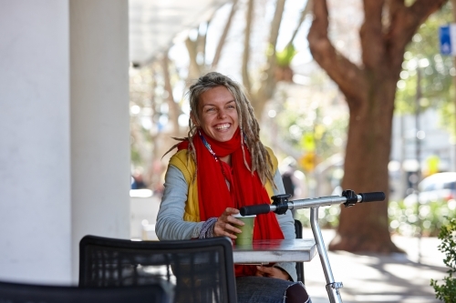 Woman with dreadlocks and scooter in city - Australian Stock Image