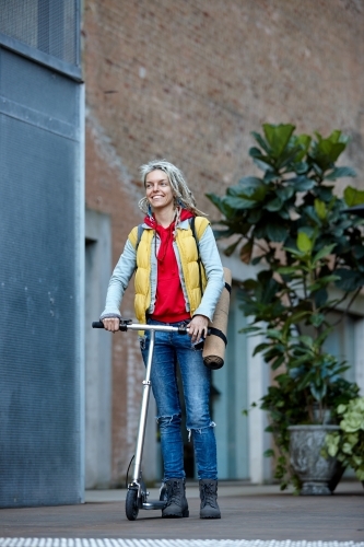 Woman with dreadlocks and scooter in city - Australian Stock Image