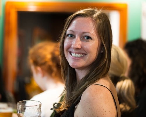 Woman with long brown hair holding a glass in her hand - Australian Stock Image