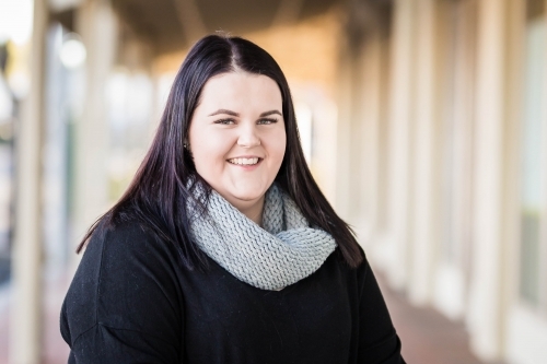 Woman with long hair wearing scarf smiling - Australian Stock Image