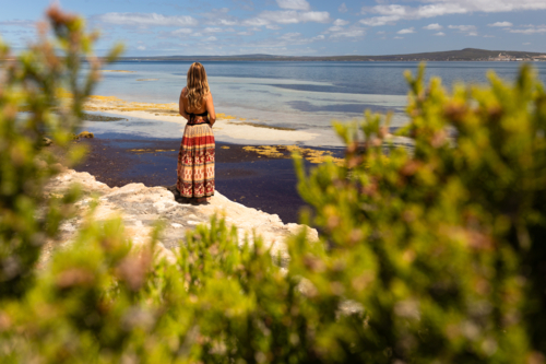 Woman with view of summer coastline on a sunny day in South Australia - Australian Stock Image