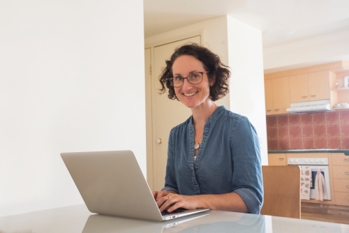 Woman working on her computer at home - Australian Stock Image