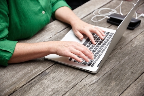 Woman working on laptop outdoors - Australian Stock Image