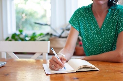 Woman writing in journal - Australian Stock Image
