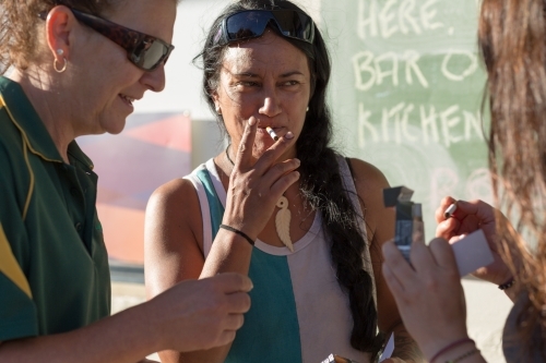 Women lighting up smokes outside a country pub