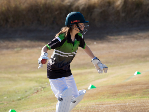 Women's cricket female wicket keeper catching the ball on the field - Australian Stock Image