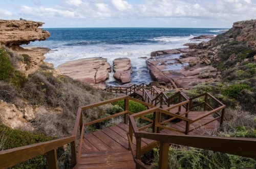 Wooden boardwalk leading down to the edge of a cliff