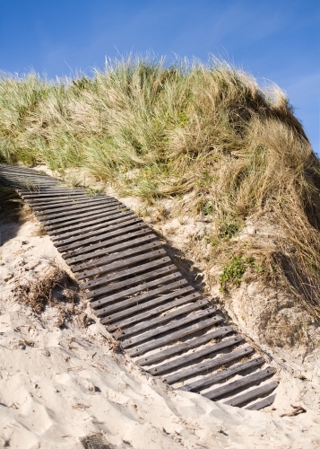 wooden boardwalk up a sand dune at a beach