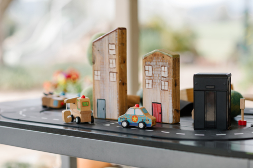 Wooden car toy and buildings on a street concept. - Australian Stock Image