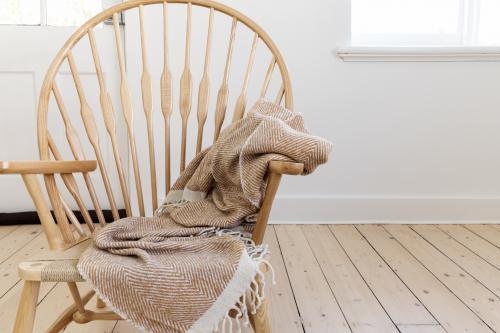 Wooden country style chair with textured throw blanket and negative space for text - Australian Stock Image