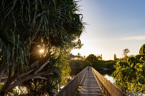 Wooden footbridge leading across Simpsons Creek at Brunswick Heads - Australian Stock Image