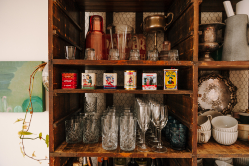 Wooden kitchen shelf displays a curated mix of vintage charm and glass wares - Australian Stock Image