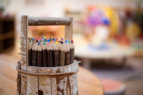 Wooden pencil holder with coloured pencils - Australian Stock Image