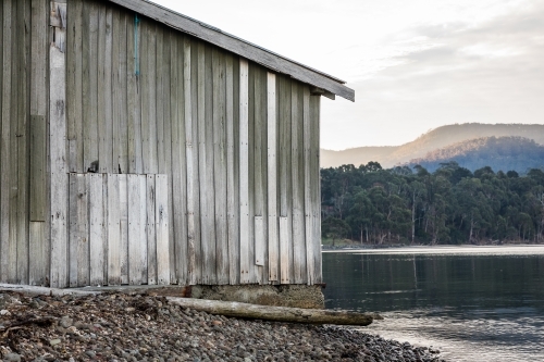 Wooden shack beside water - Australian Stock Image