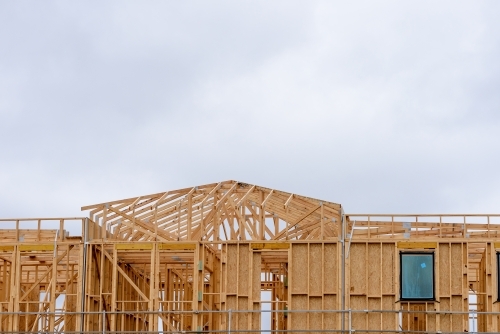 Wooden structure of house being built on construction site.