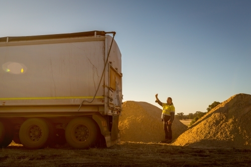 Worker directing reversing truck - Australian Stock Image