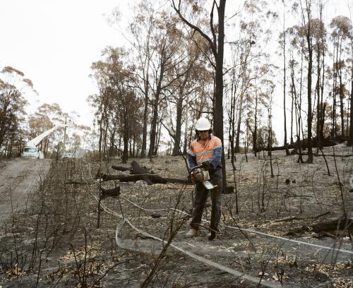 Workmen repairing power lines in bushfire ravaged landscape - Australian Stock Image