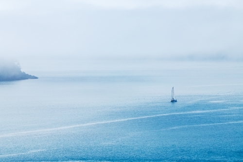 yacht sailing into sea fog - Australian Stock Image