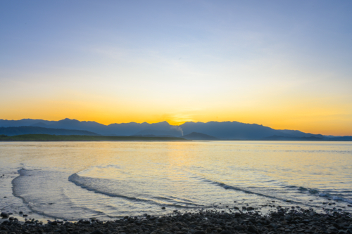 Yellow and blue sunset across water in Port Douglas - Australian Stock Image