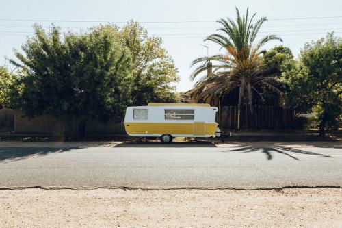 Yellow and white caravan parked in street