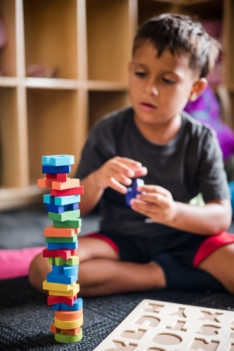 Young Aboriginal boy doing a letter puzzle - Australian Stock Image