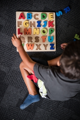 Young Aboriginal boy doing a letter puzzle