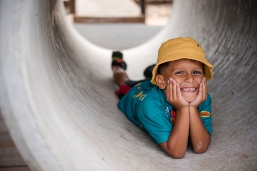 Young Aboriginal boy lying in a tunnel - Australian Stock Image