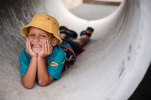 Young Aboriginal boy lying in a tunnel - Australian Stock Image