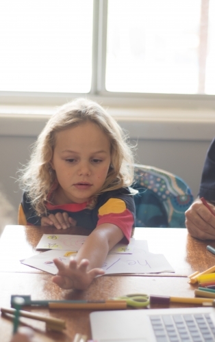 Young Aboriginal girl writing - Australian Stock Image