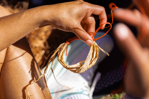 Young Aboriginal person weaving bracelet - Australian Stock Image