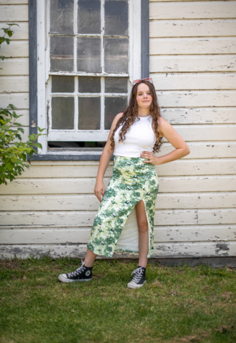 Young adult female posing in front of old window of a country shed - Australian Stock Image