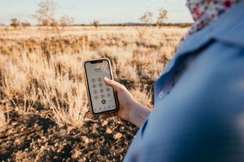 Young Adult Holding a Smartphone on Farm - Australian Stock Image