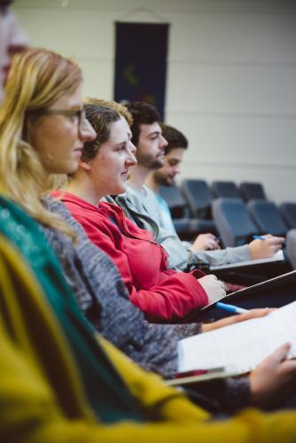 Young adult students listening to professor a university lecture hall