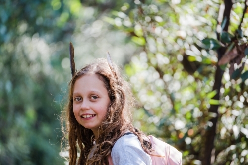 Young adventurer with feathers in her hair. - Australian Stock Image
