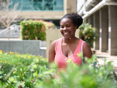 Young African woman in university courtyard - Australian Stock Image