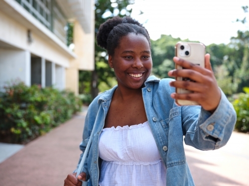 Young African woman taking a selfie on a university campus - Australian Stock Image