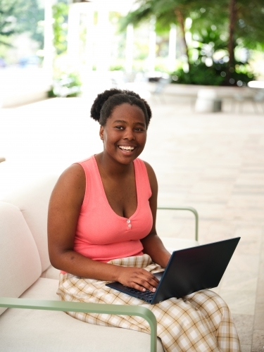 Young African woman using a laptop on university campus - Australian Stock Image