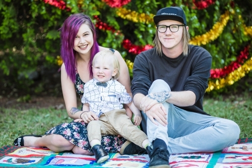 Young alternative family sitting smiling at christmas time - Australian Stock Image