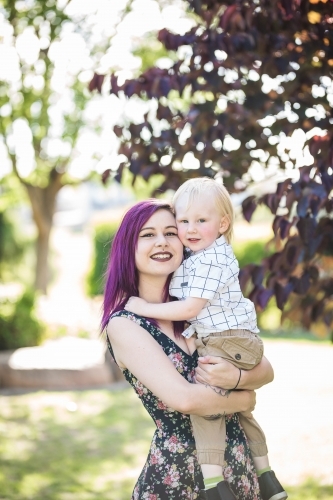 Young alternative mother cuddling child - Australian Stock Image