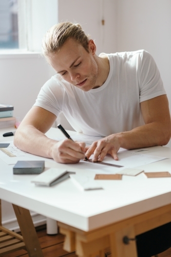 Young architect working on a house design vertical - Australian Stock Image