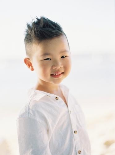 Young Asian boy outside, smiling - Australian Stock Image