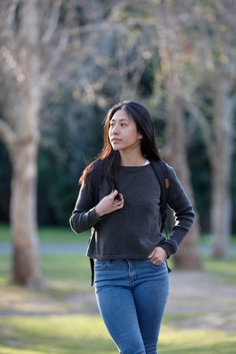 Young Asian female university student outdoors at park - Australian Stock Image